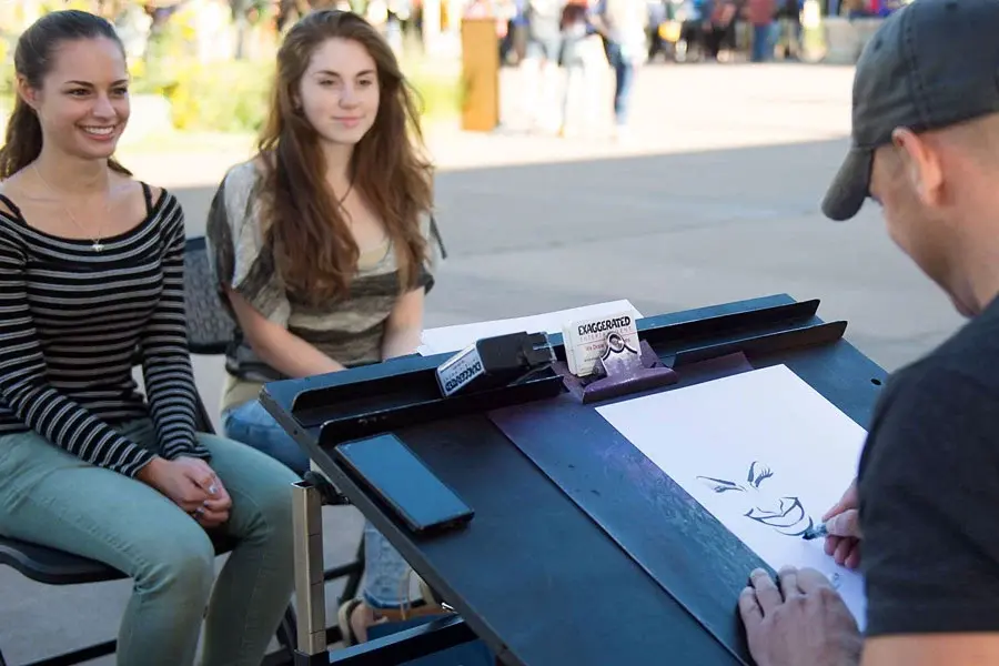 Caricaturist Drawing Two Friends At An Event