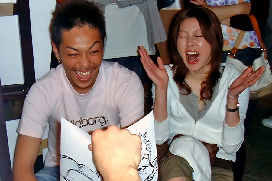 Couple Laughing At Their Caricature At An Event
