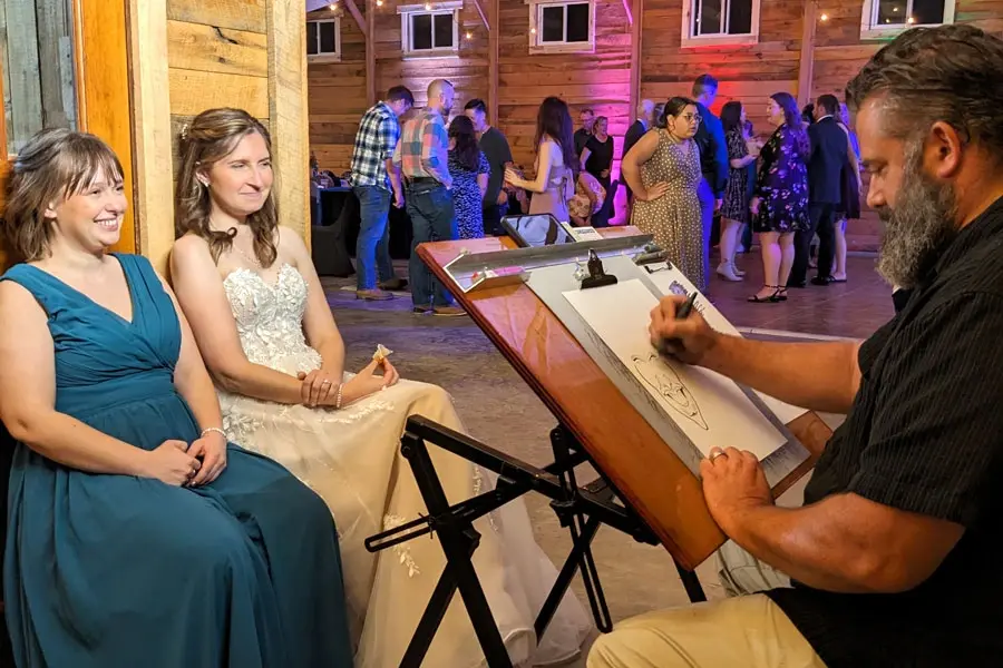 Caricaturist Drawing The Bride And Maid Of Honor At A Wedding Reception